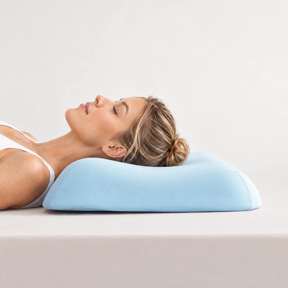 Back sleeper using a light blue CASUCA contour memory foam pillow