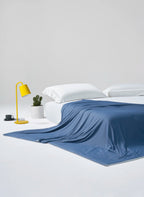 Prussian blue CASUCA cooling comforter draped over a bed