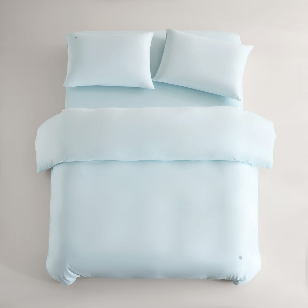 blue CASUCA cooling pet-hair-resistant bedding set styled in a pet-friendly bedroom