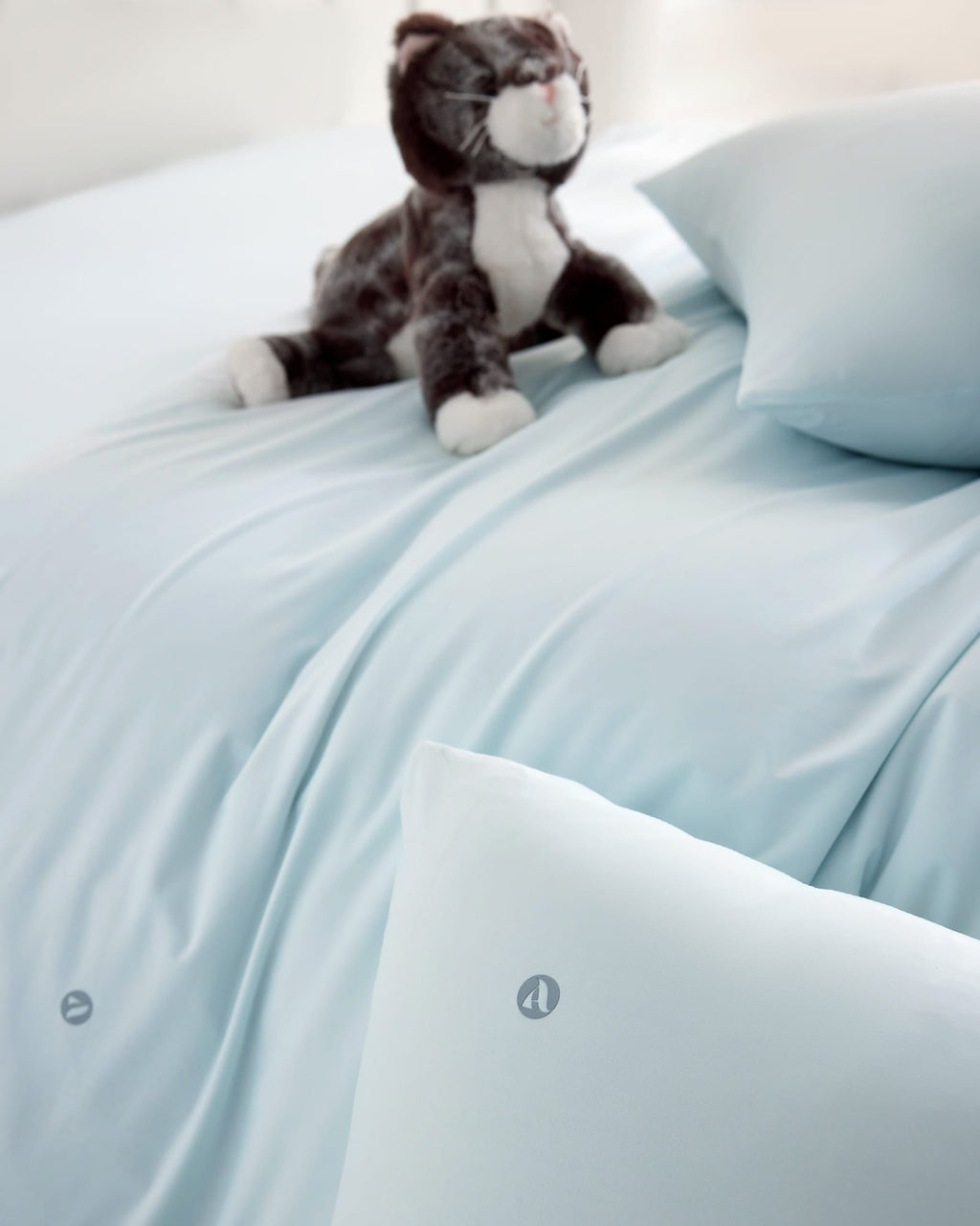 blue CASUCA cooling pet-hair-resistant bedding set styled in a pet-friendly bedroom