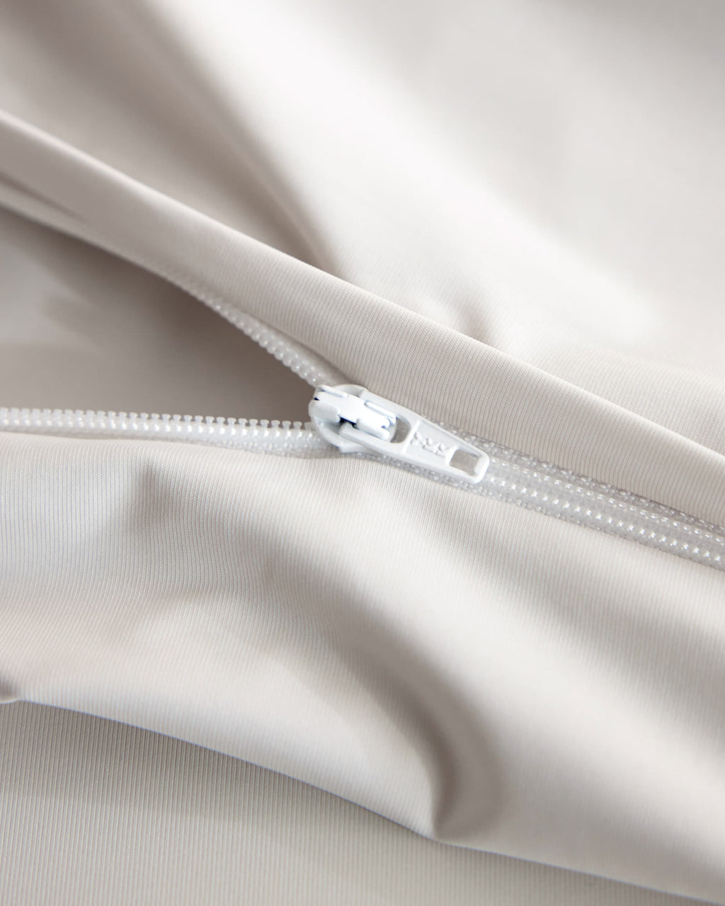 Concealed zipper detail on the oatmeal CASUCA cooling pet-hair-resistant bedding set