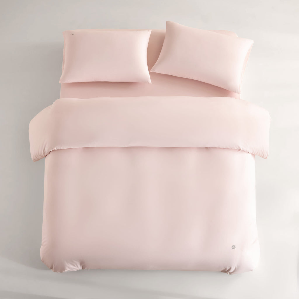 pink CASUCA cooling pet-hair-resistant bedding set styled in a pet-friendly bedroom
