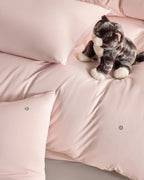 pink CASUCA cooling pet-hair-resistant bedding set styled in a pet-friendly bedroom