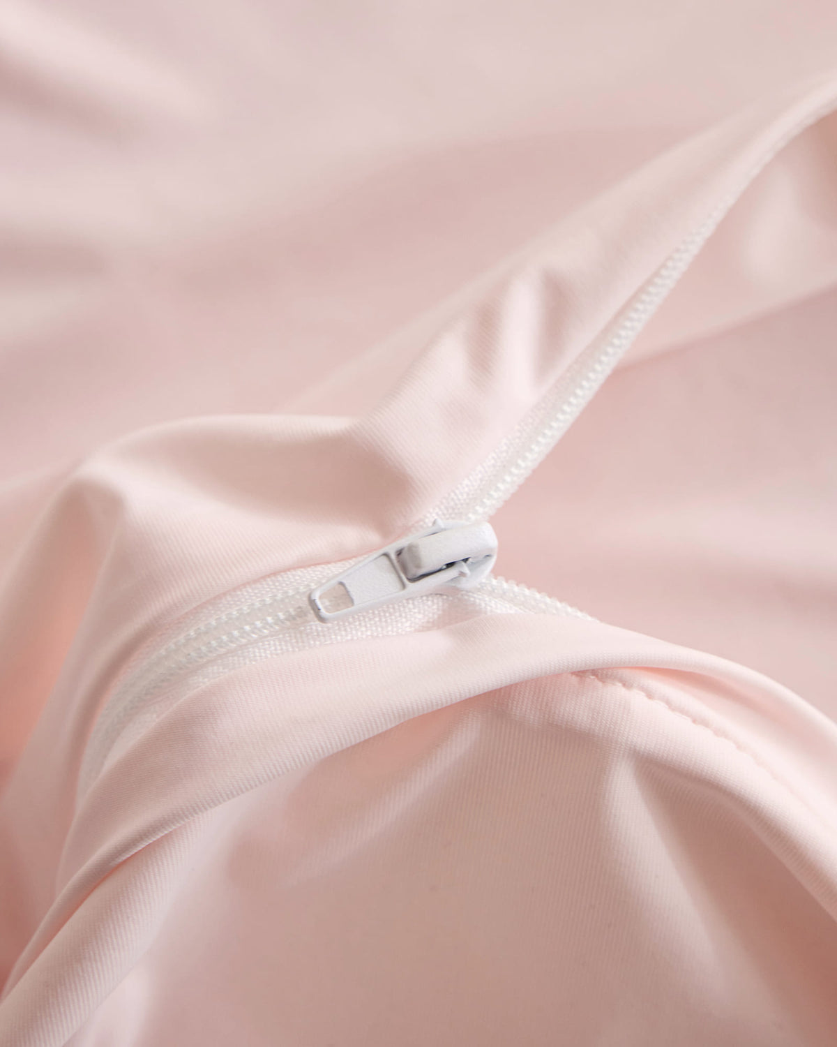 Concealed zipper detail on the pink CASUCA cooling pet-hair-resistant bedding set