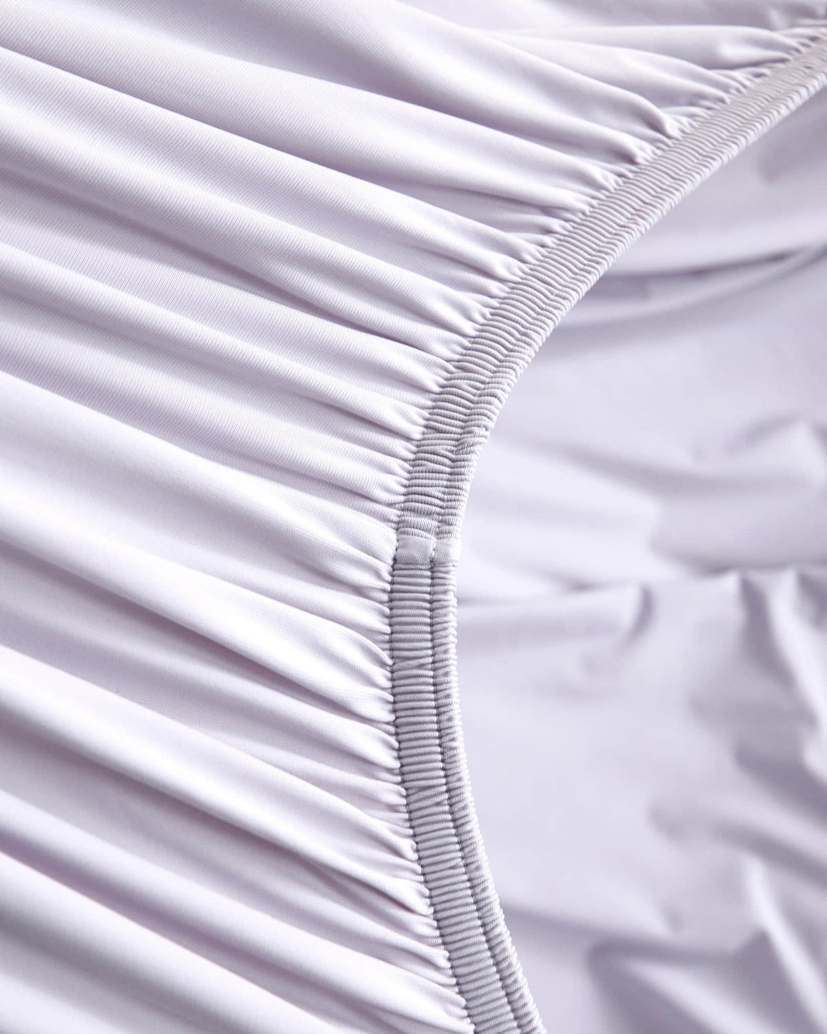 Fitted sheet elastic detail on the purple CASUCA cooling pet-hair-resistant bedding set
